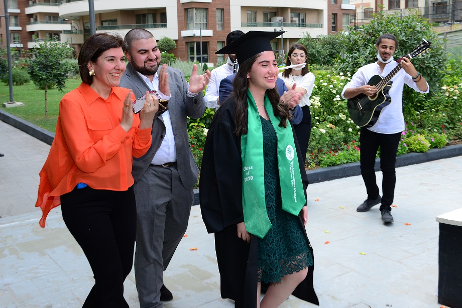 ISC-Erbil senior receiving her cap and gown at a surprise drop-off with the band